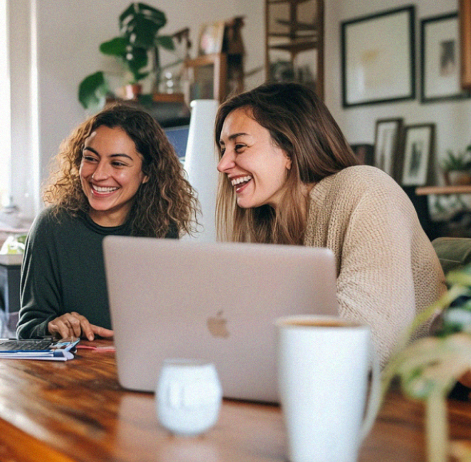 A group of people sitting around a laptop computer.